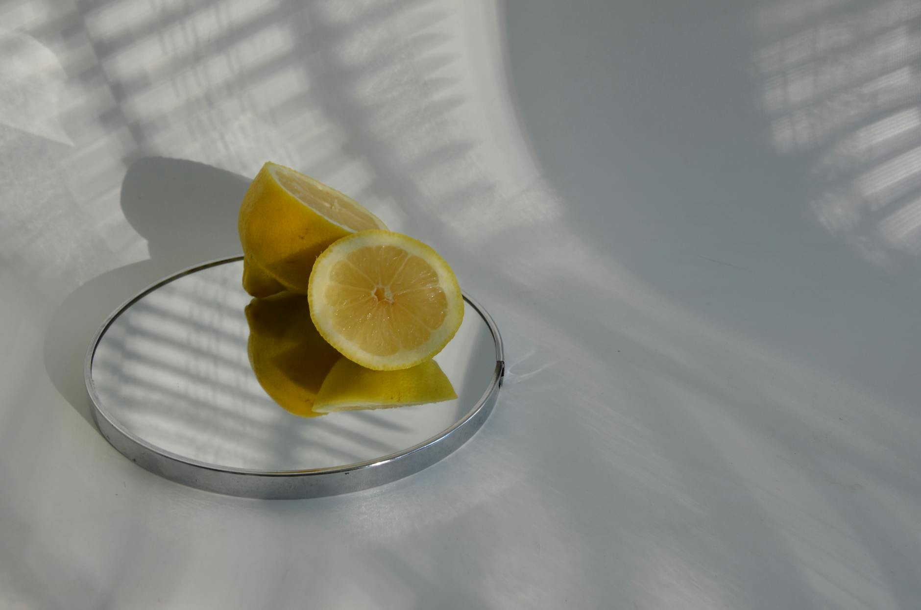 Sliced lemons on a mirror casting shadows, illustrating the fresh, focused sensation of lemon vibrators
